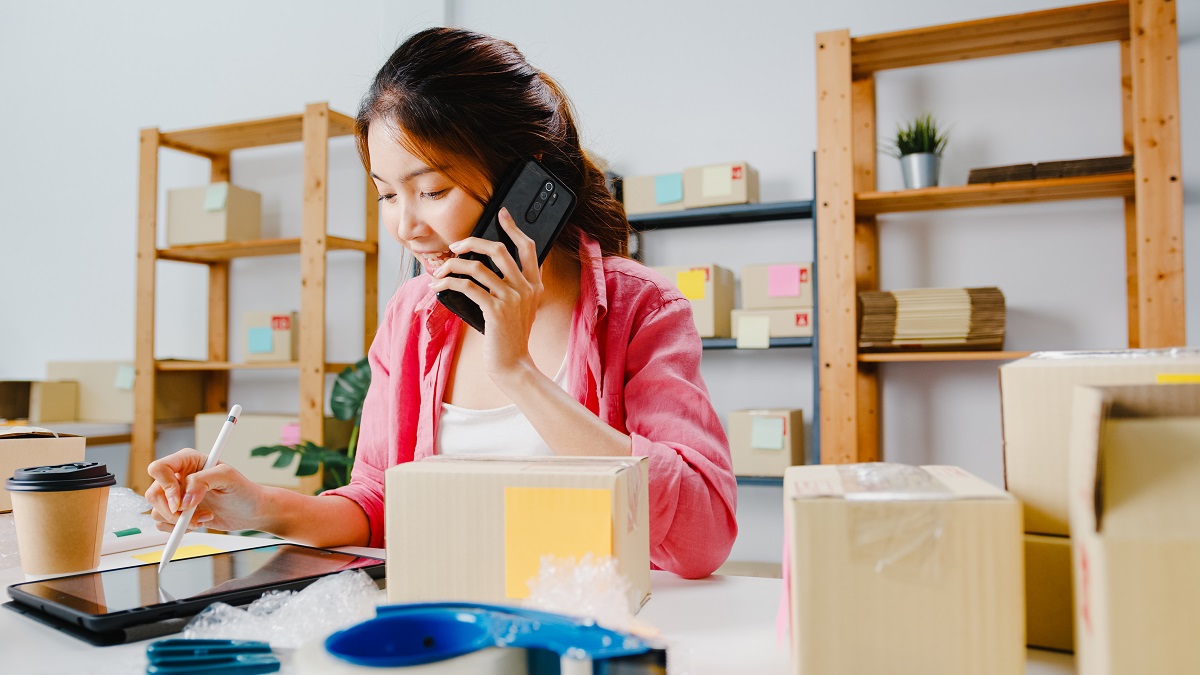 young-asia-businesswoman-using-mobile-phone-call-receiving-purchase-order-check-product-stock-work-home-office-small-business-owner-online-market-delivery-lifestyle-freelance-concept